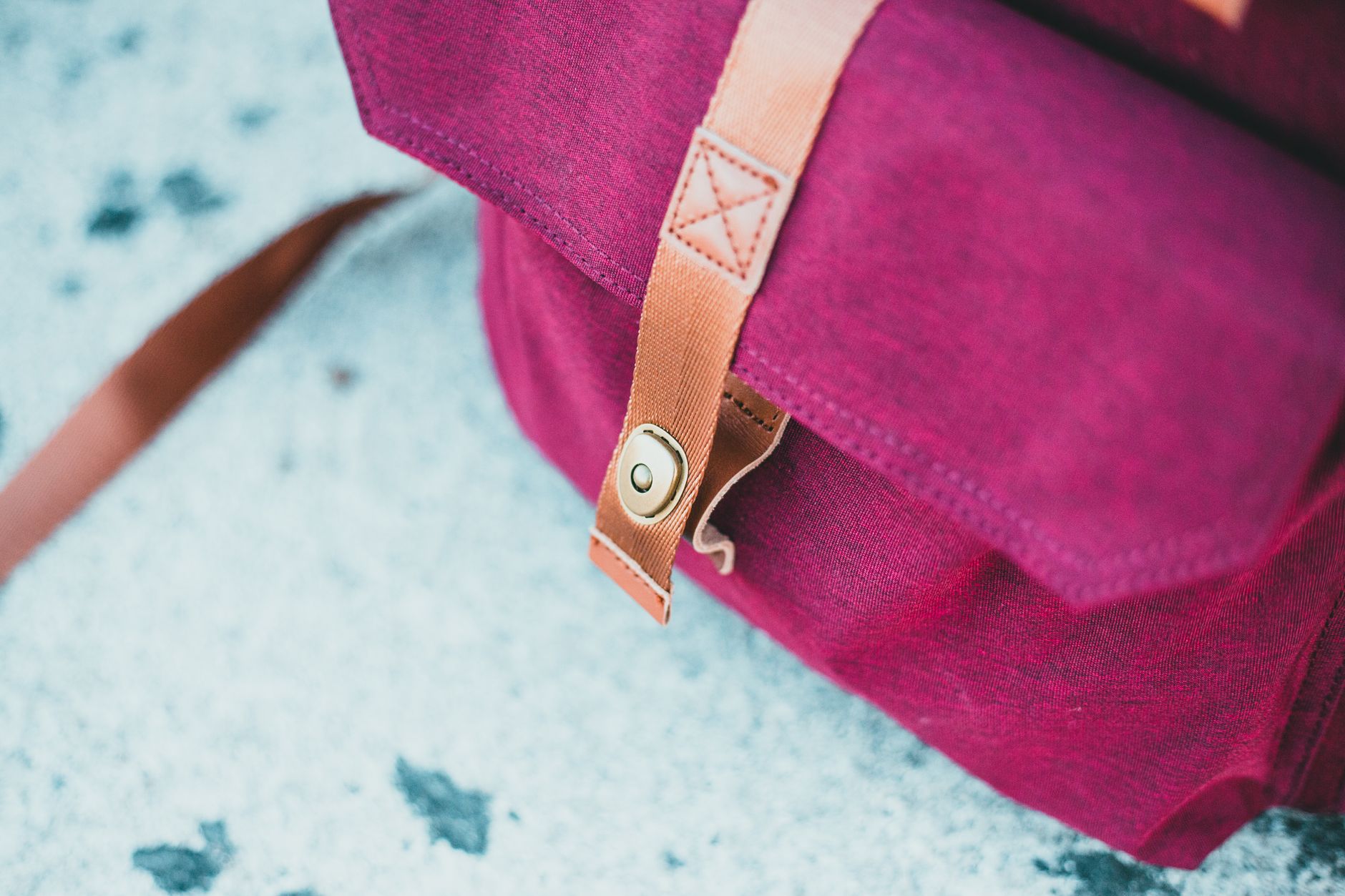 A burgundy leather bag being carried on the street
