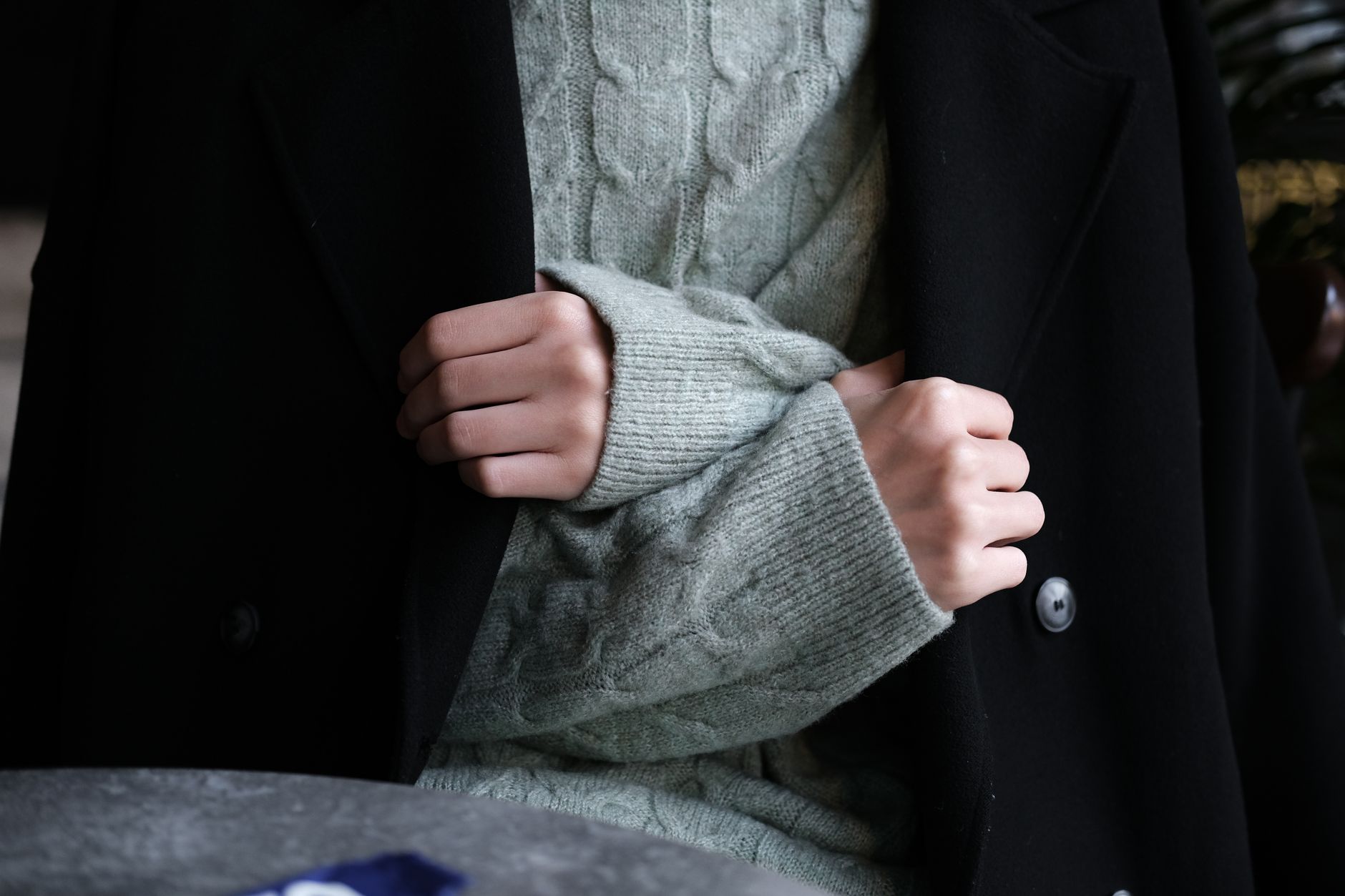 A neutral coat and sweater layered outfit