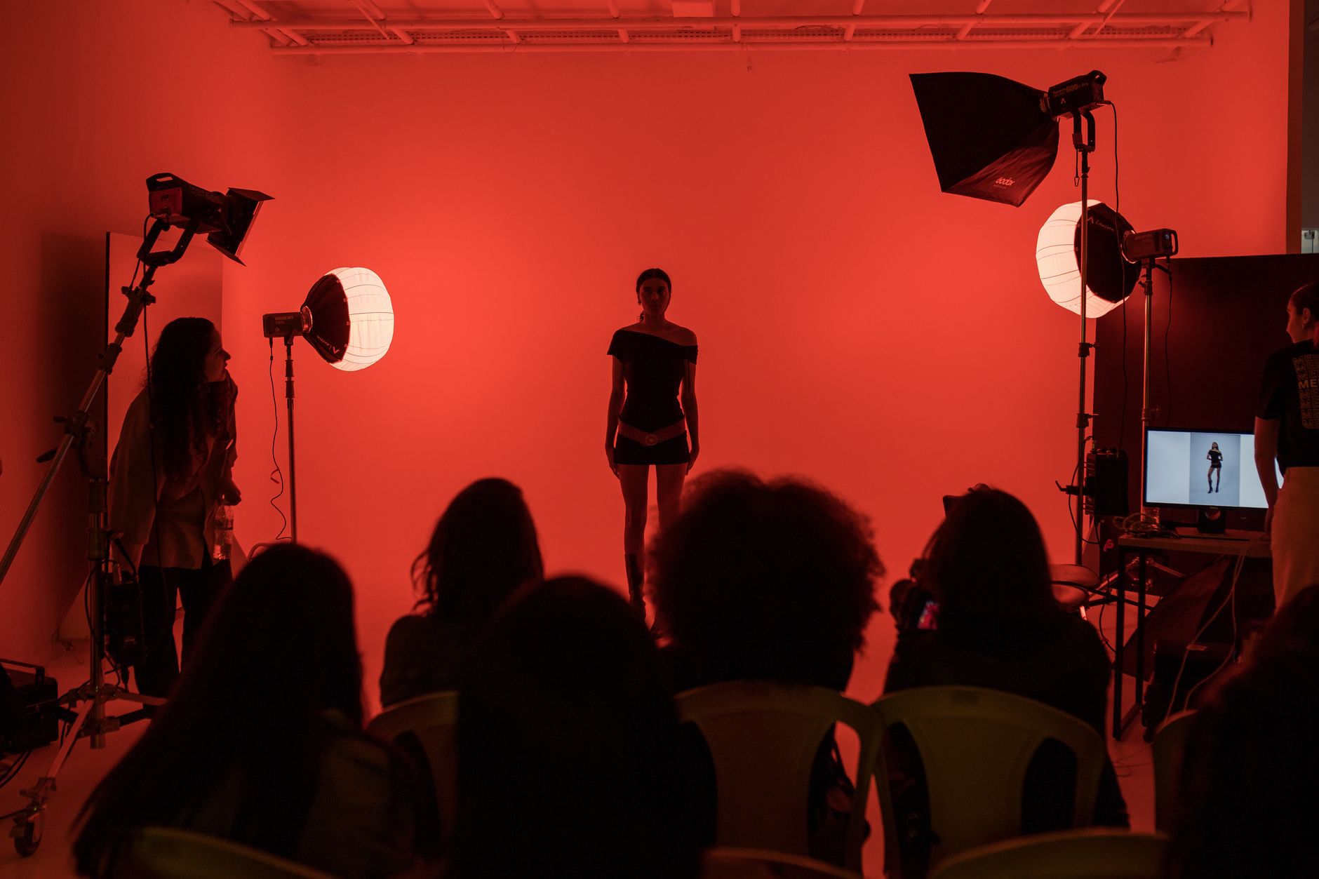 A runway model walking under editorial lights