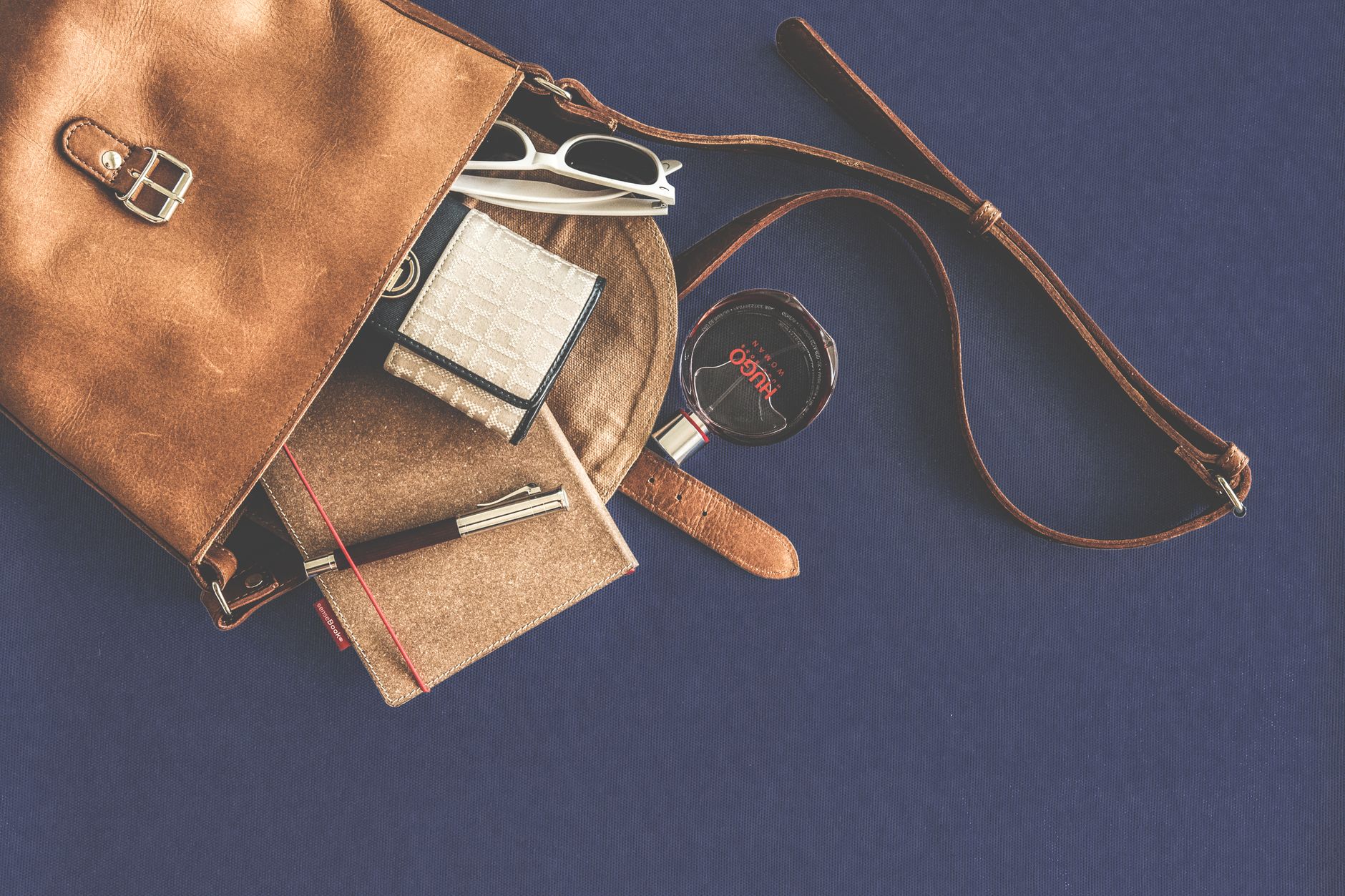 A vintage leather handbag on a marble surface