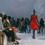 Elegant fashion runway model walking in a designer sheer gown at fashion week