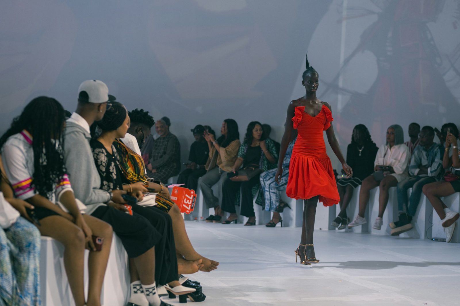 Elegant fashion runway model walking in a designer sheer gown at fashion week